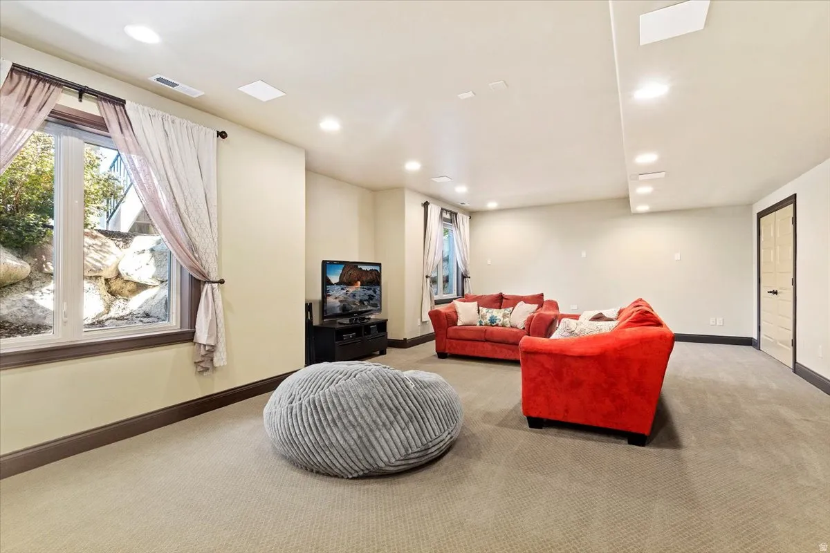 Recessed lighting illuminates this room featuring light-toned walls and carpeted flooring