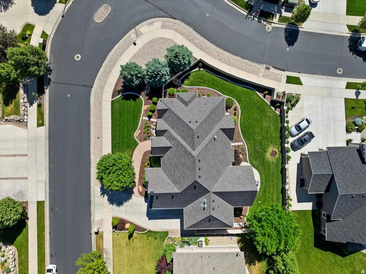 Expansive residential property with a multi-gabled roofline, featuring a curved driveway, mature trees, and manicured lawns