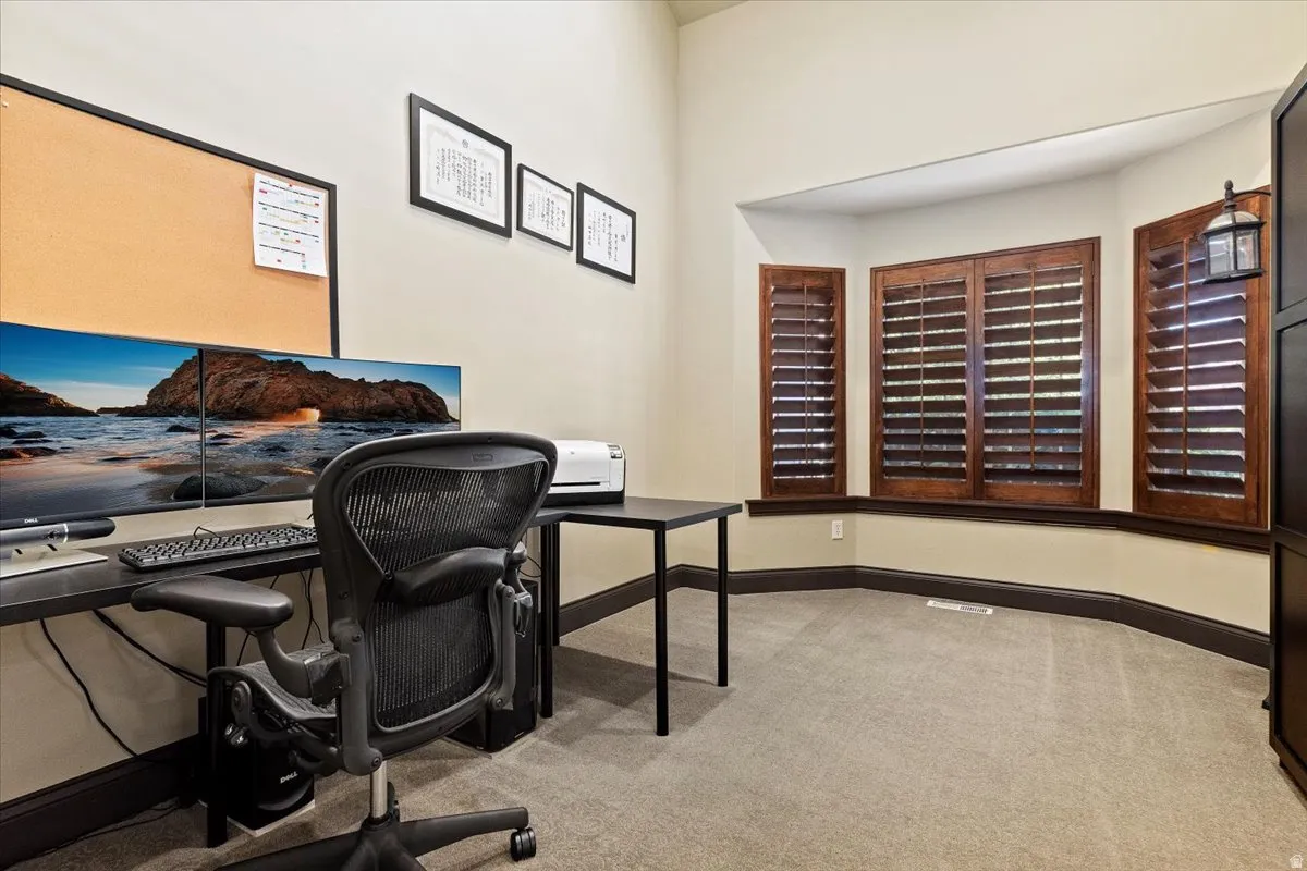 Recessed bay window featuring wooden plantation shutters, complemented by dark wood trim and neutral wall tones