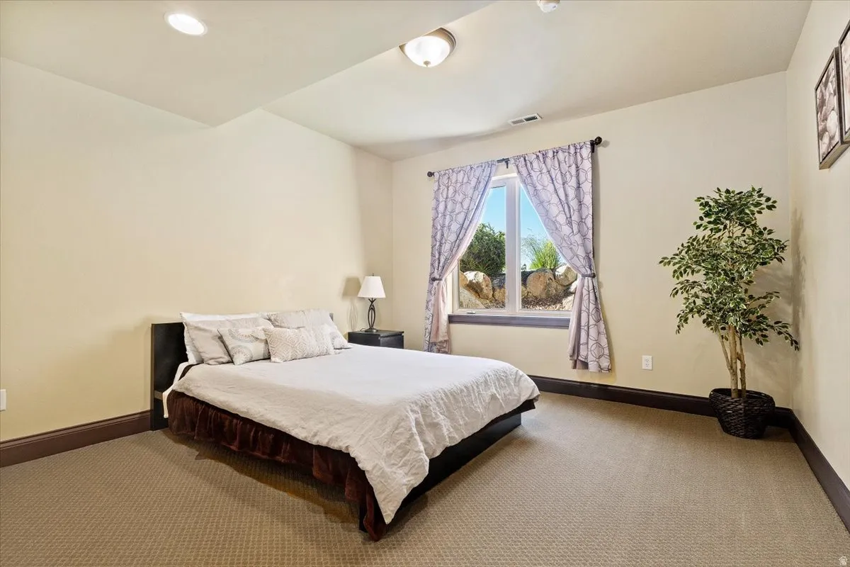Wall-to-wall carpeted room featuring a window with broad trim, recessed lighting, and a flush mount ceiling fixture
