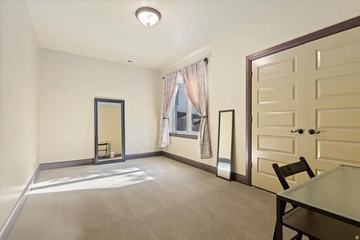 Room featuring neutral-toned walls, recessed lighting, and light-colored carpeting