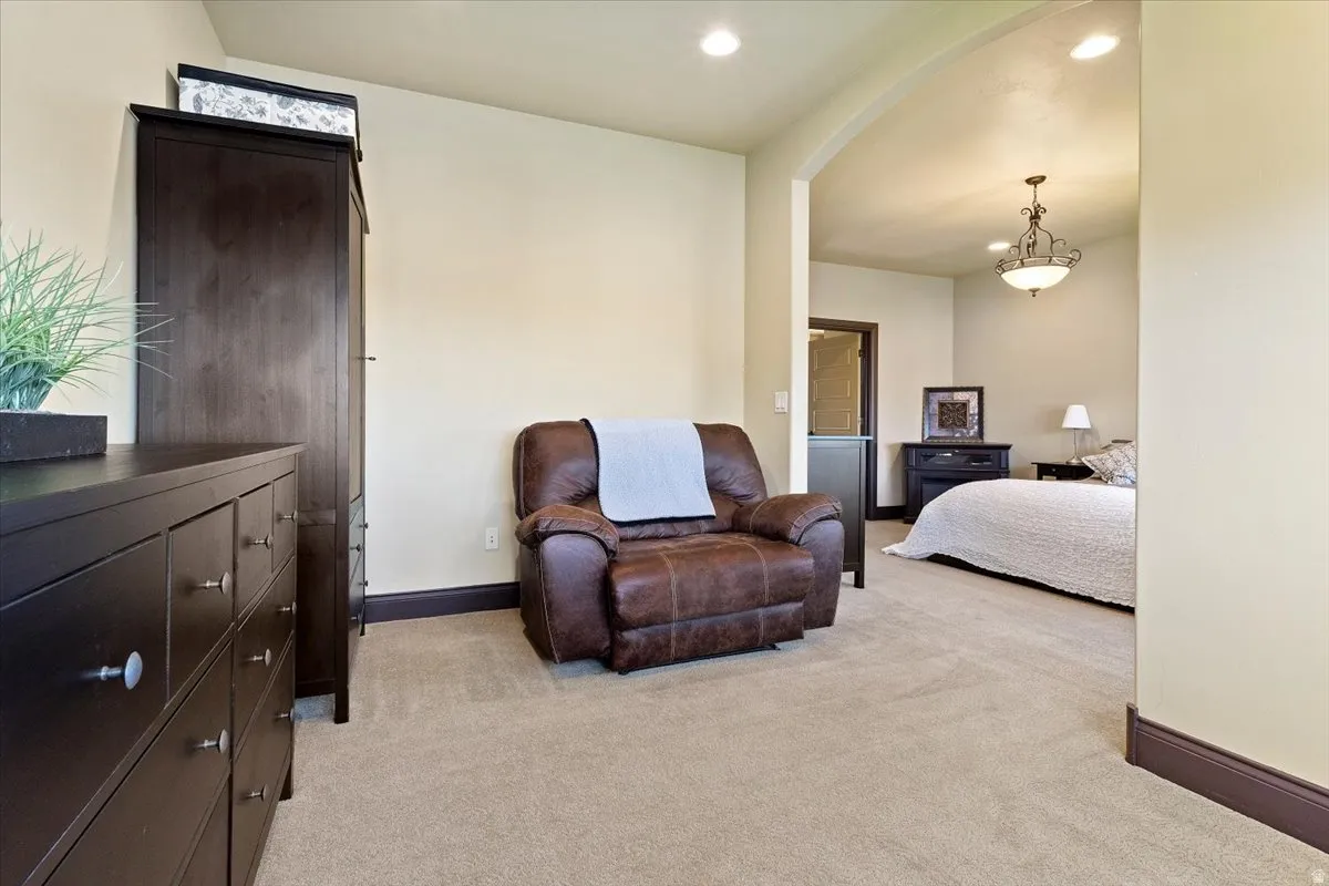 Archway entry with recessed lighting, light beige carpeting, dark wood-finish trim, and a decorative ceiling fixture