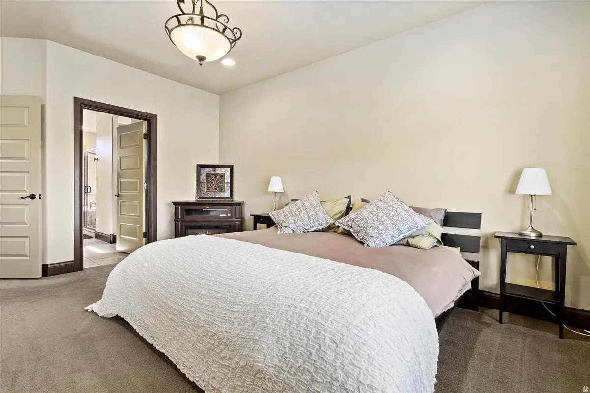 Carpeted room featuring light-toned walls and a decorative ceiling light fixture