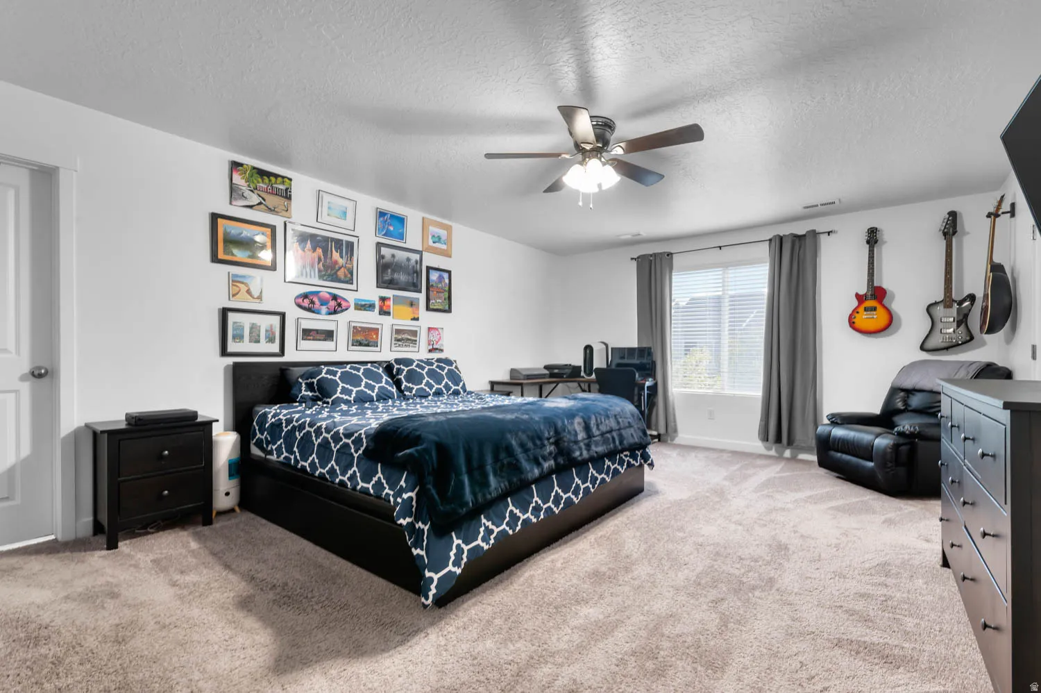 Spacious room featuring neutral carpeting, a ceiling fan with integrated lighting, and a large window with privacy blinds