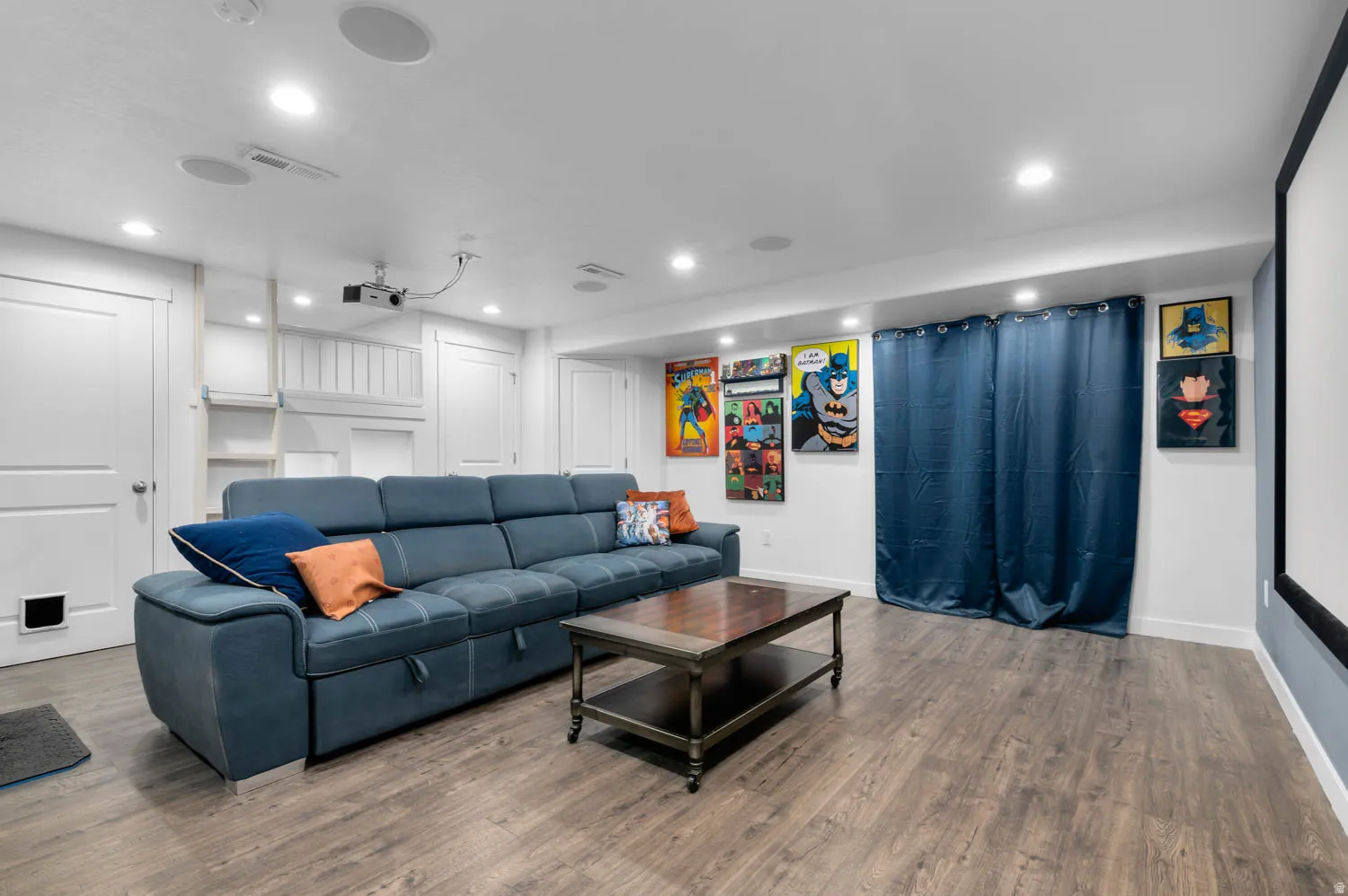 Lower-level recreation space featuring wood-finish flooring, recessed lighting, and built-in ceiling speakers