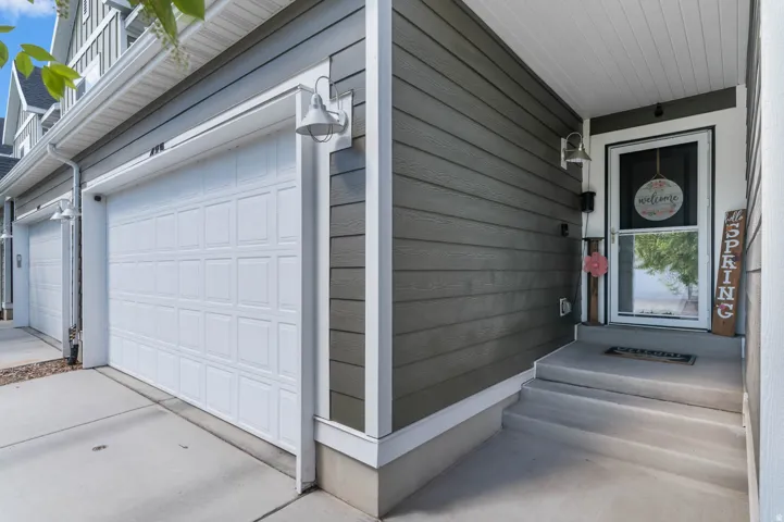 Entryway featuring horizontal siding, a white storm door, and a concrete porch with steps