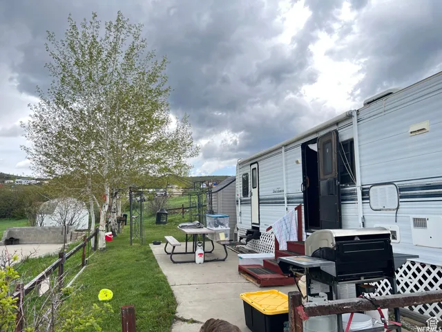 Compact living structure featuring horizontal siding, an entry door with a screen, and an awning