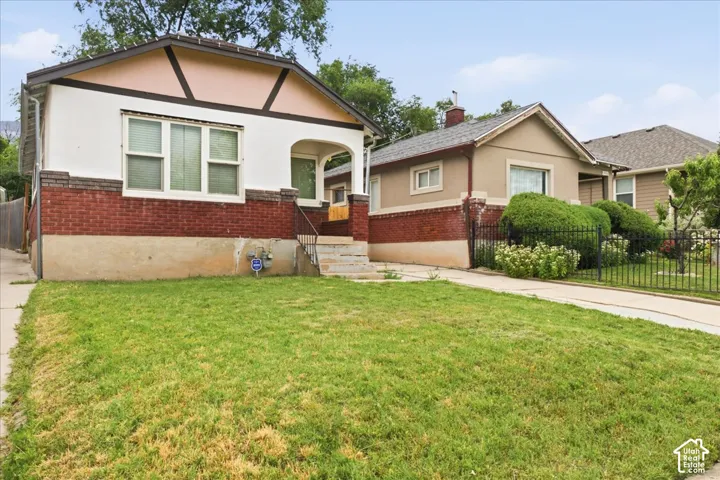 Traditional-style home featuring a red brick lower facade and white upper siding with decorative dark trim