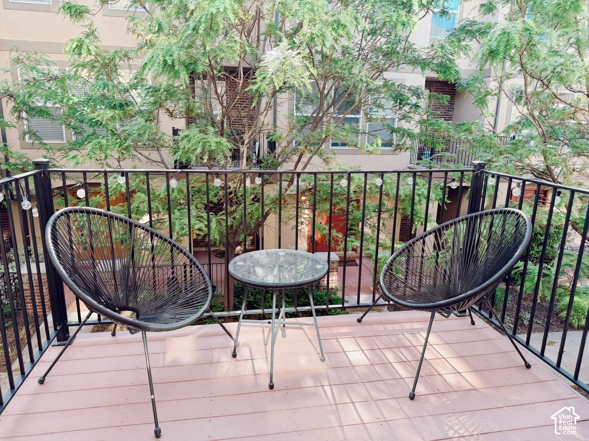 Private balcony featuring a black metal railing and wood-finish decking