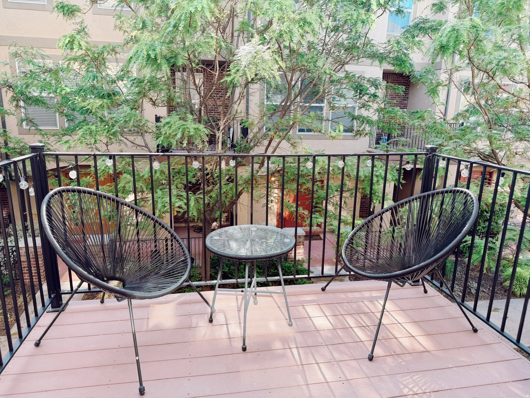 Private balcony featuring a black metal railing and wood-finish decking