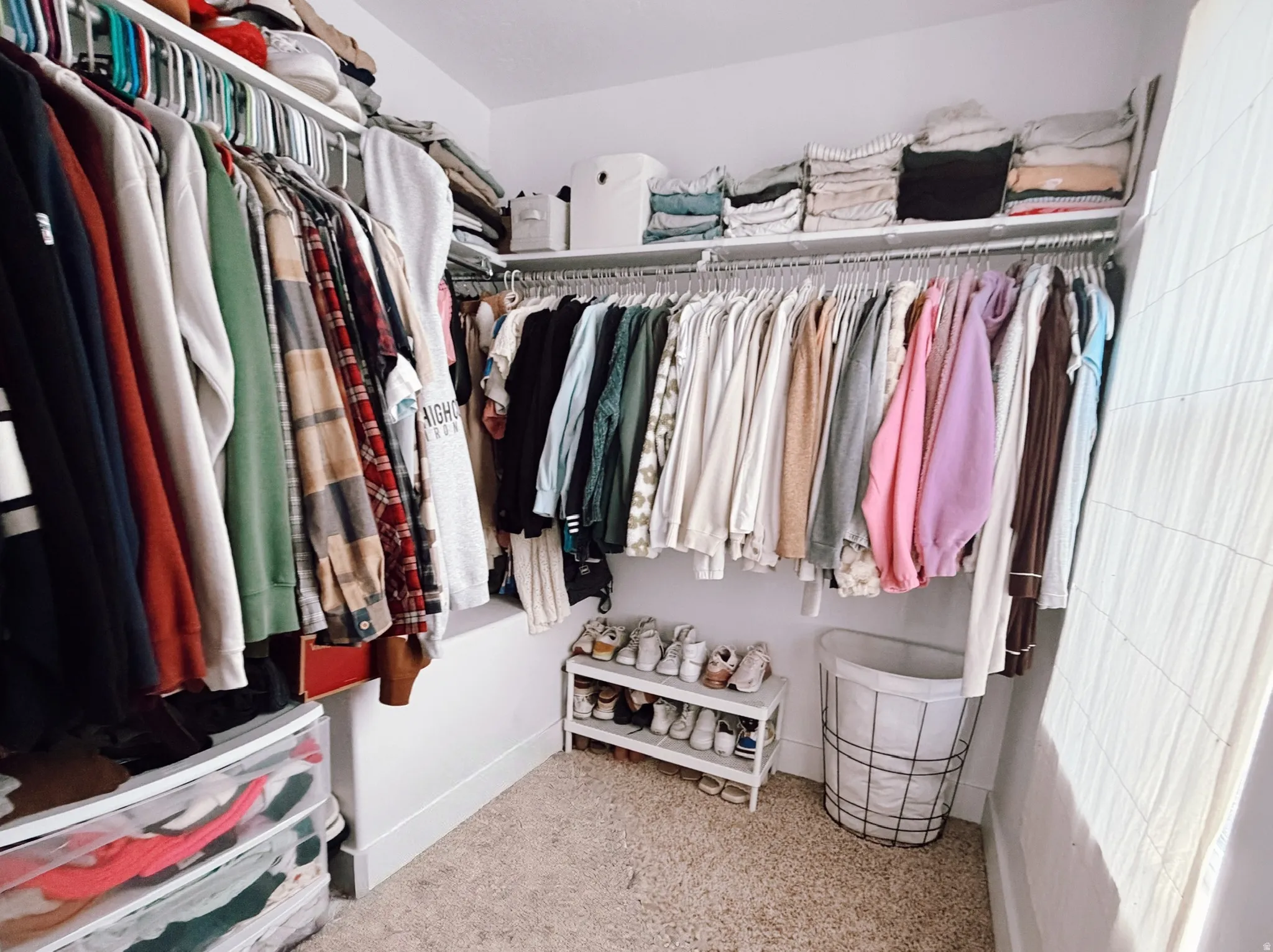 Walk-in master closet featuring extensive built-in shelving and hanging rods