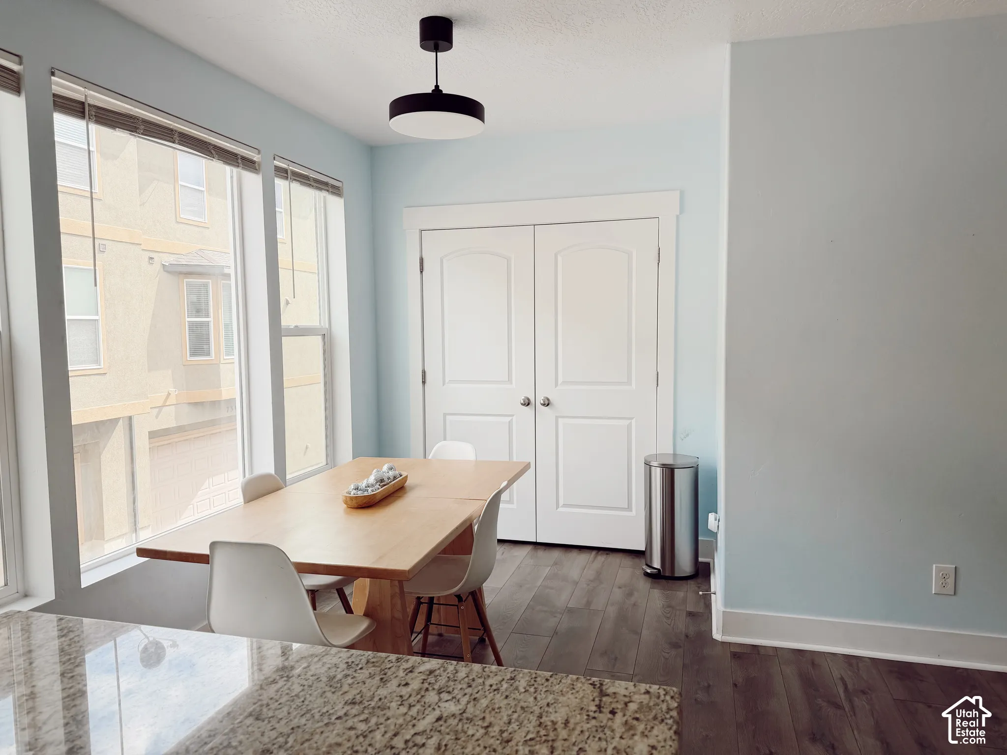 Expansive windows, wood-finish flooring, and a modern ceiling light fixture
