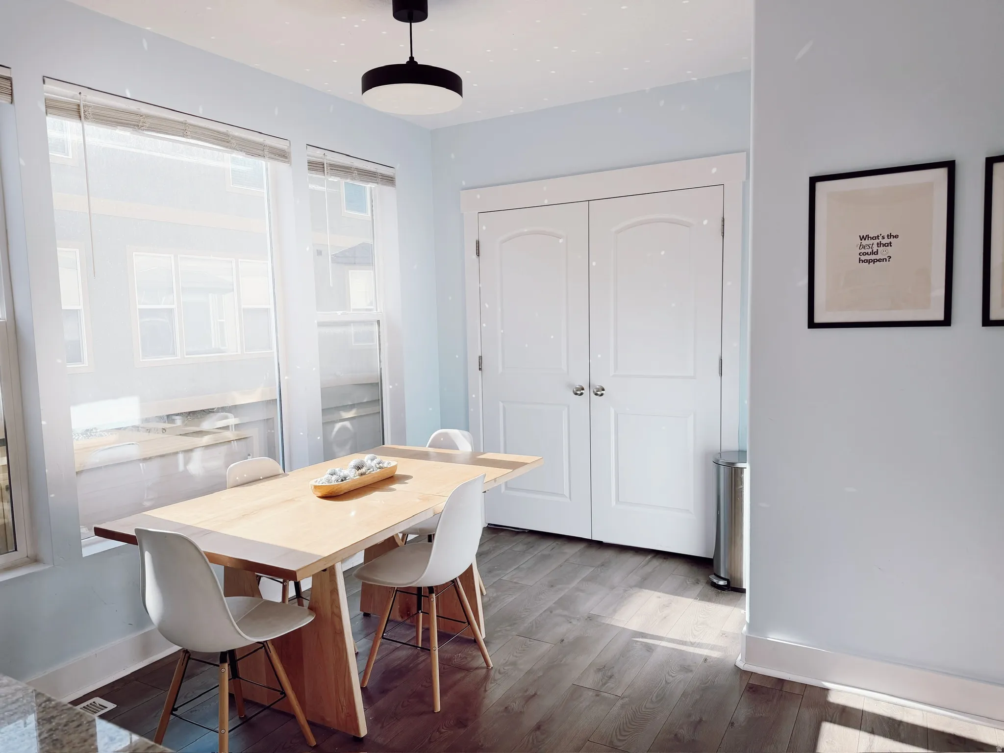 Dining space and pantry area featuring wood-finish flooring, light blue walls, and a modern ceiling fixture