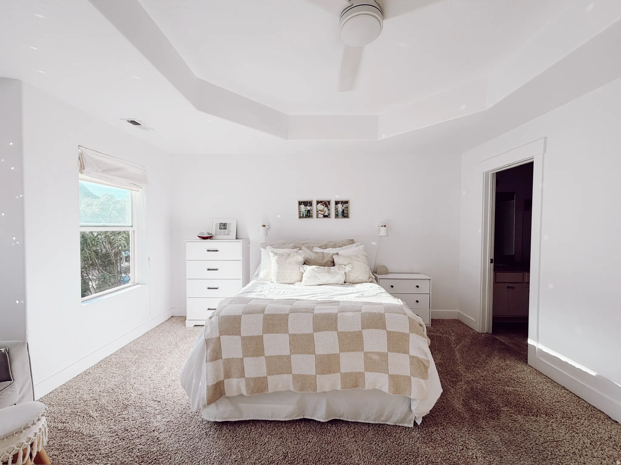 Master bedroom showing a tray ceiling with recessed lighting and a ceiling fan