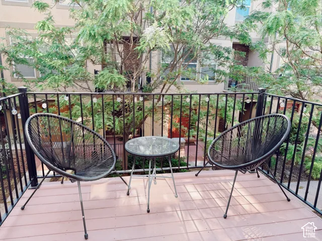 Private balcony featuring a black metal railing and wood-finish decking