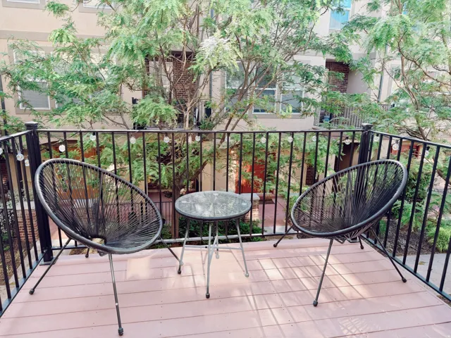 Private balcony featuring a black metal railing and wood-finish decking