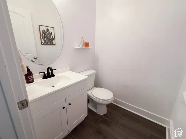 White vanity with shaker-style cabinetry, matte black faucet, and oval mirror