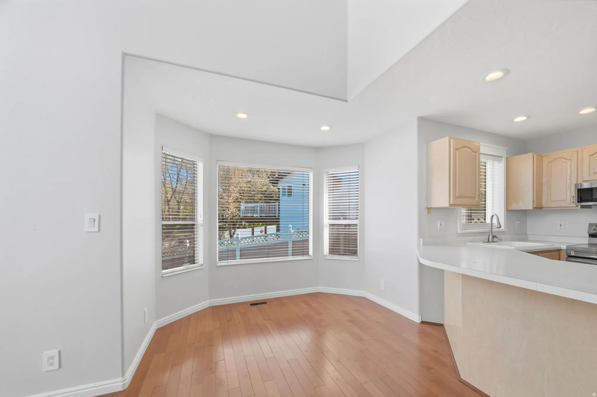 Bay window dining area featuring wood-finish flooring and recessed lighting