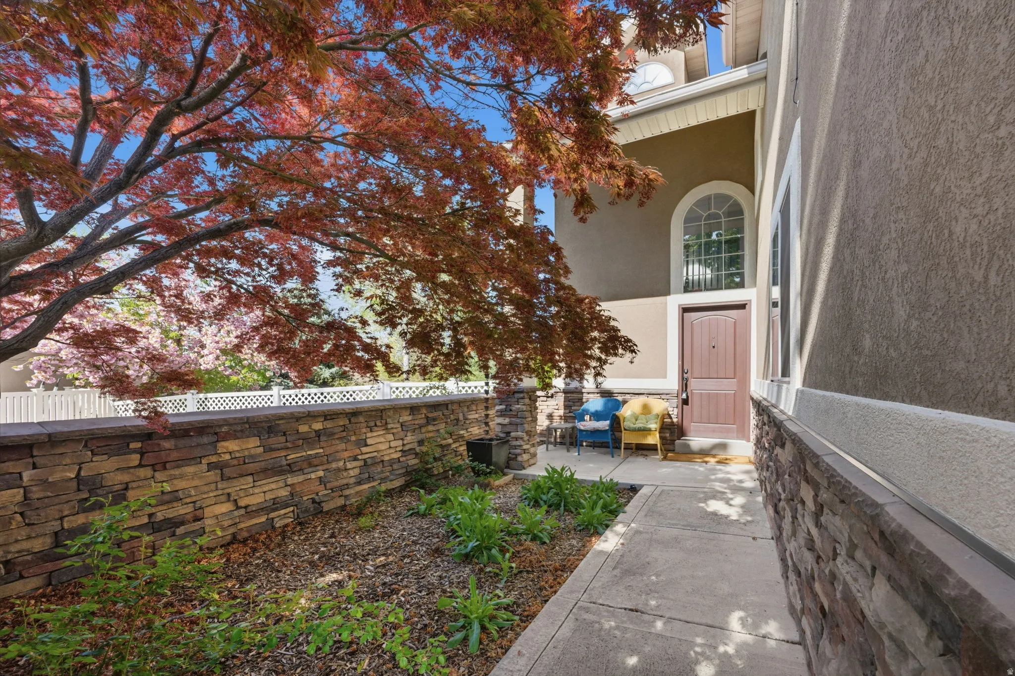 Entryway featuring an arched transom window, a paneled door, and a stone veneer facade