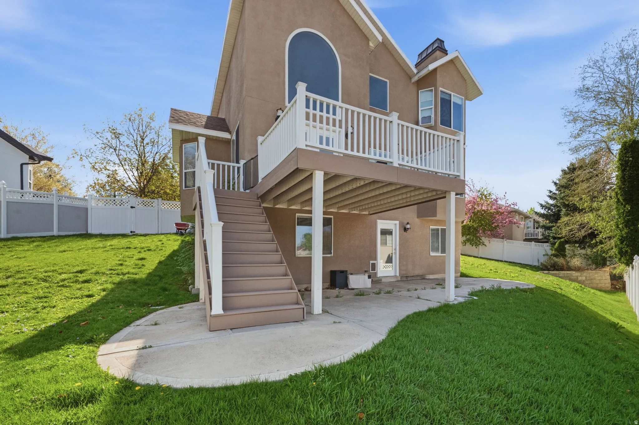 Elevated rear deck with white railing, accessed via exterior stairs