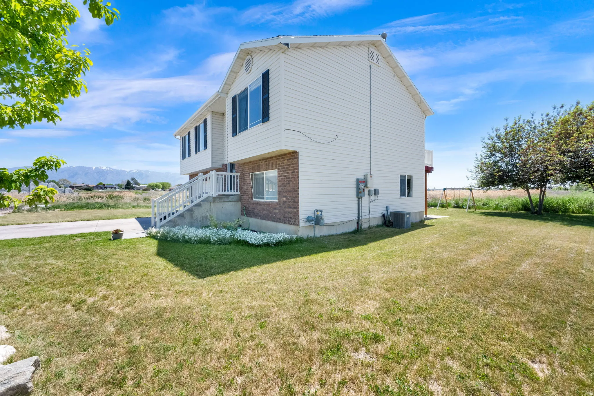 White siding exterior with brick accents