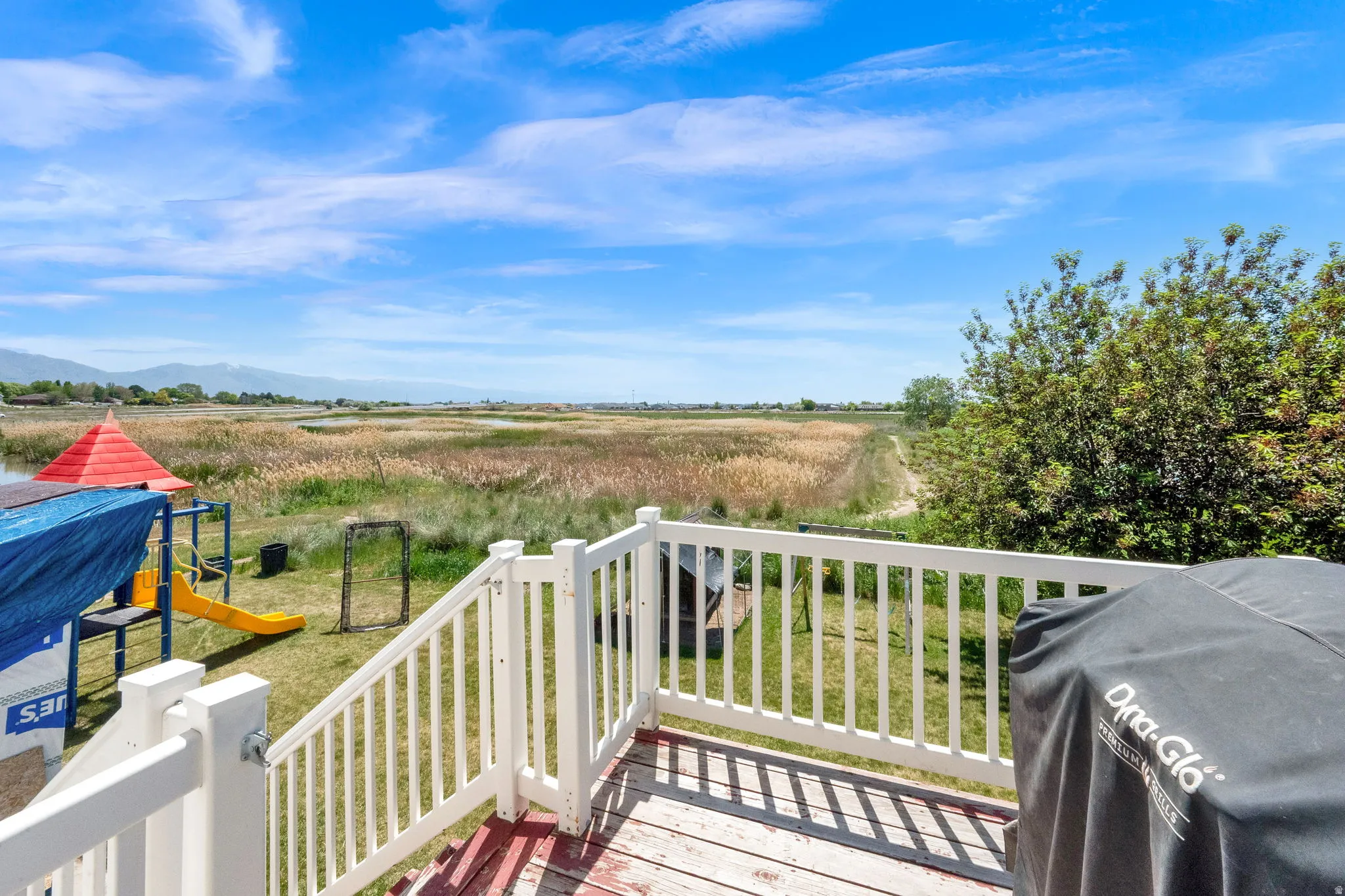 Expansive outdoor deck with white railings and a natural wood-finish floor
