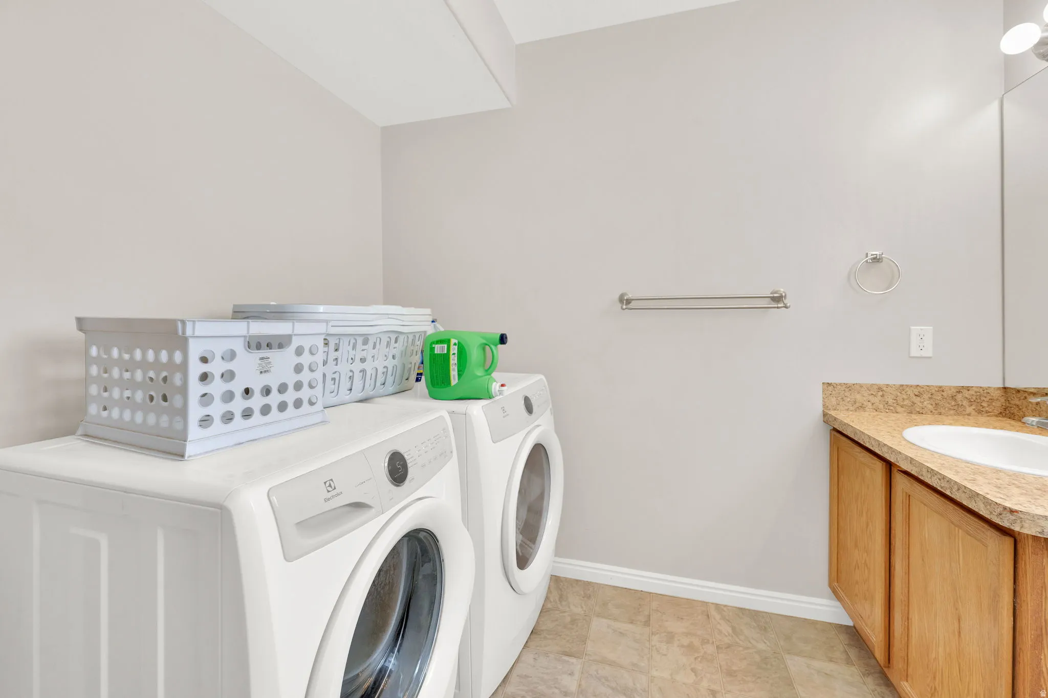 Laundry room with built-in cabinetry, an integrated sink, and an overhead light fixture