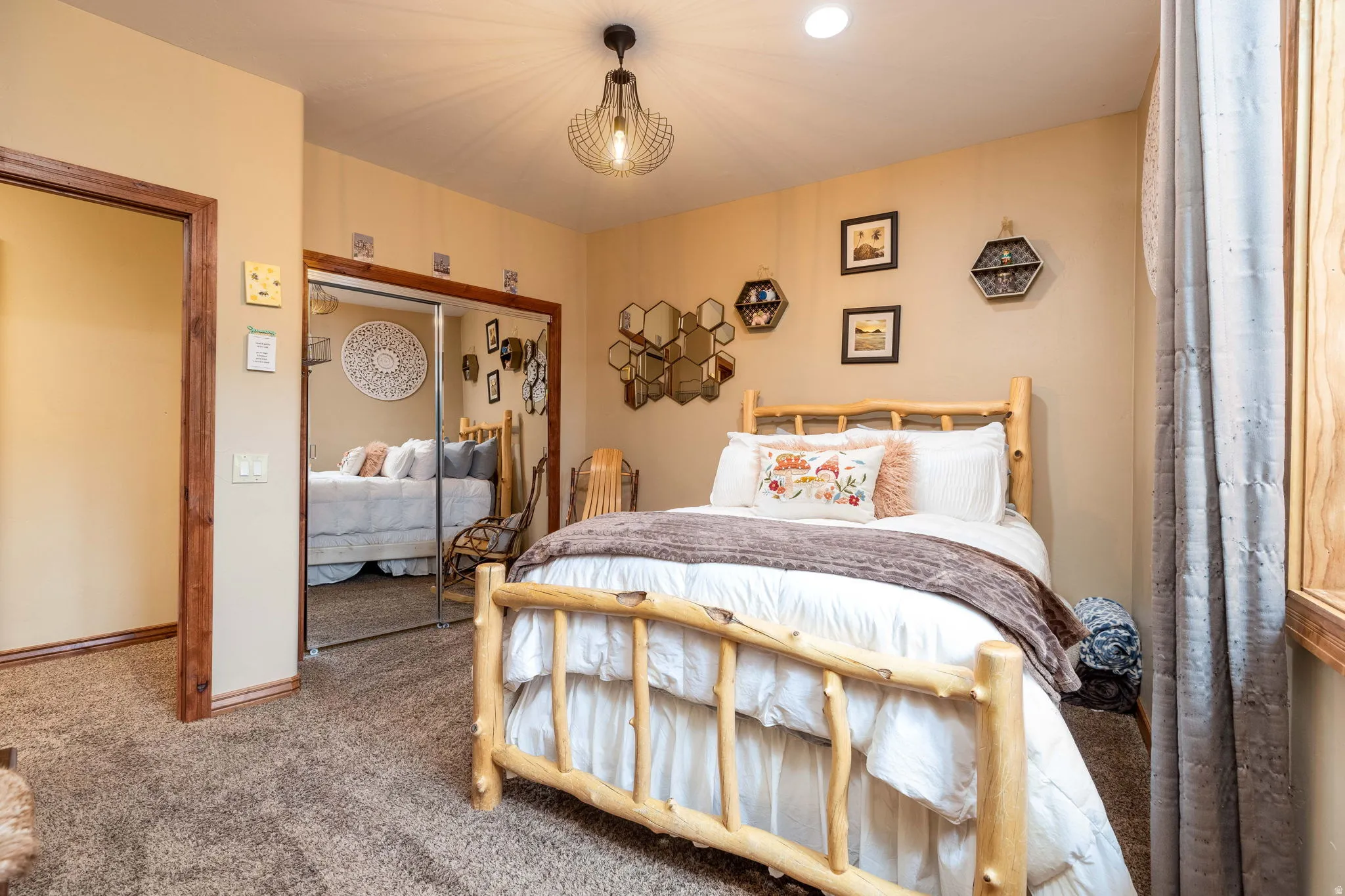 Carpeted bedroom featuring a rustic wood bed frame, recessed lighting, and a modern geometric pendant light fixture