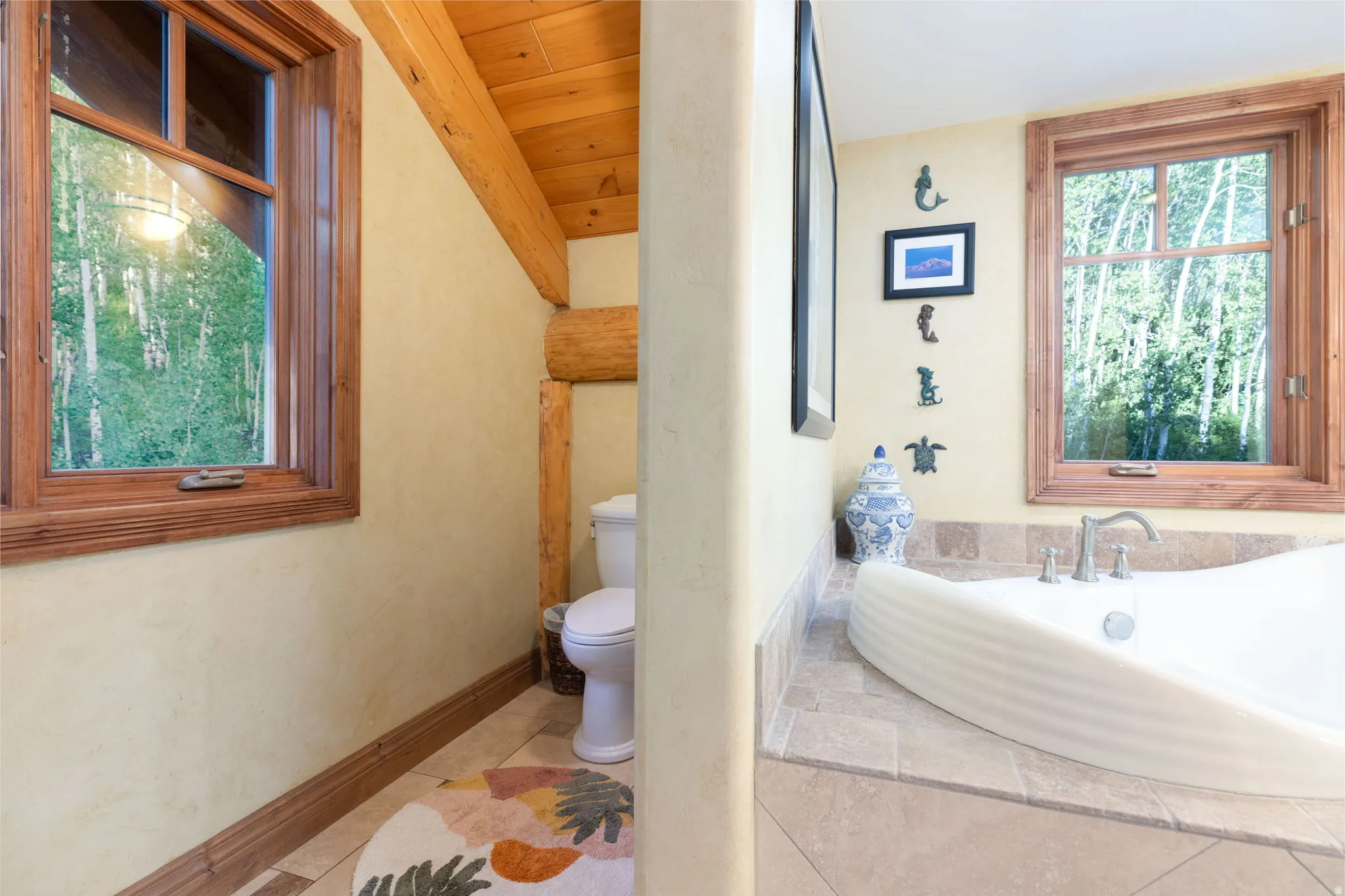 Tile flooring featuring wood trim and a corner soaking tub with a tiled surround and chrome fixtures