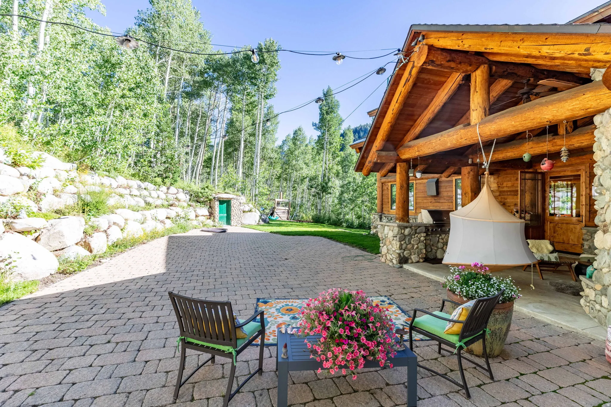 Expansive paver patio bordered by a natural stone retaining wall