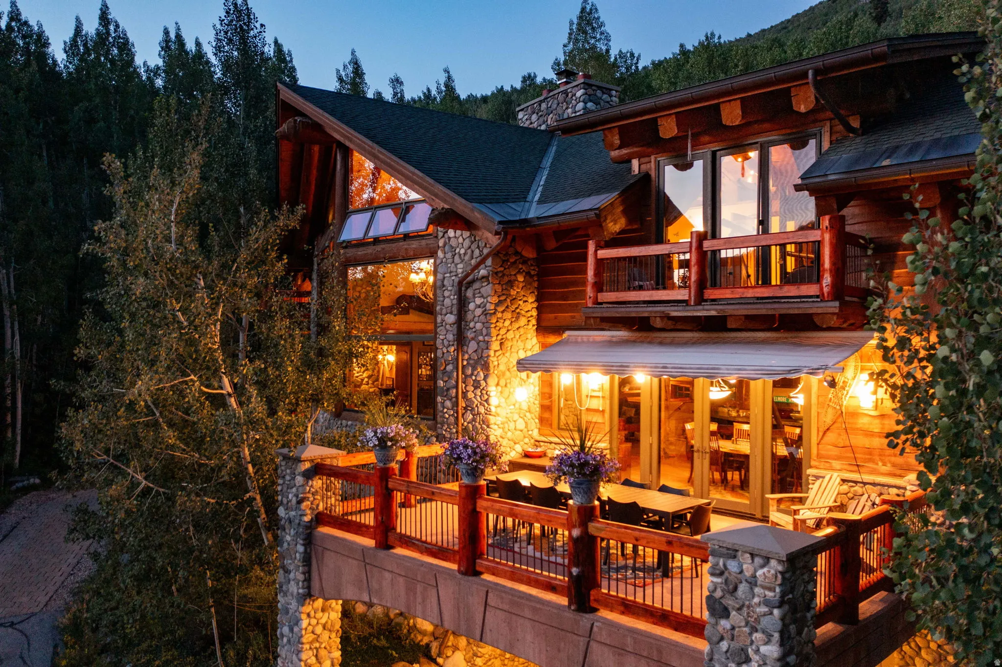 Multi-level stone and log exterior with a prominent gabled roofline