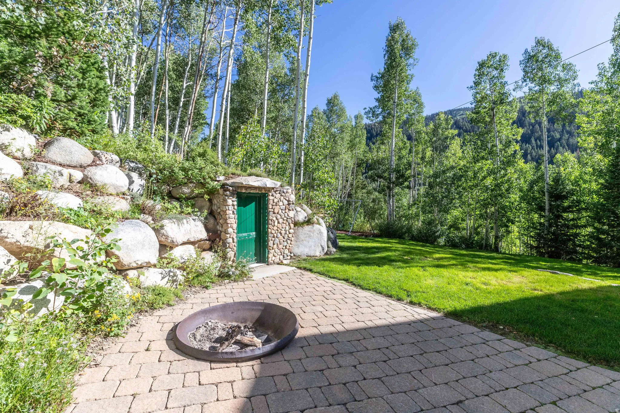 Expansive outdoor space featuring a paver patio and a surrounding green lawn