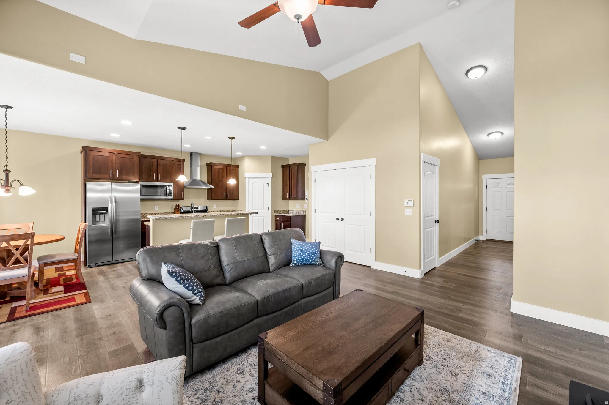 Open-concept living area featuring wood-finish flooring and vaulted ceilings