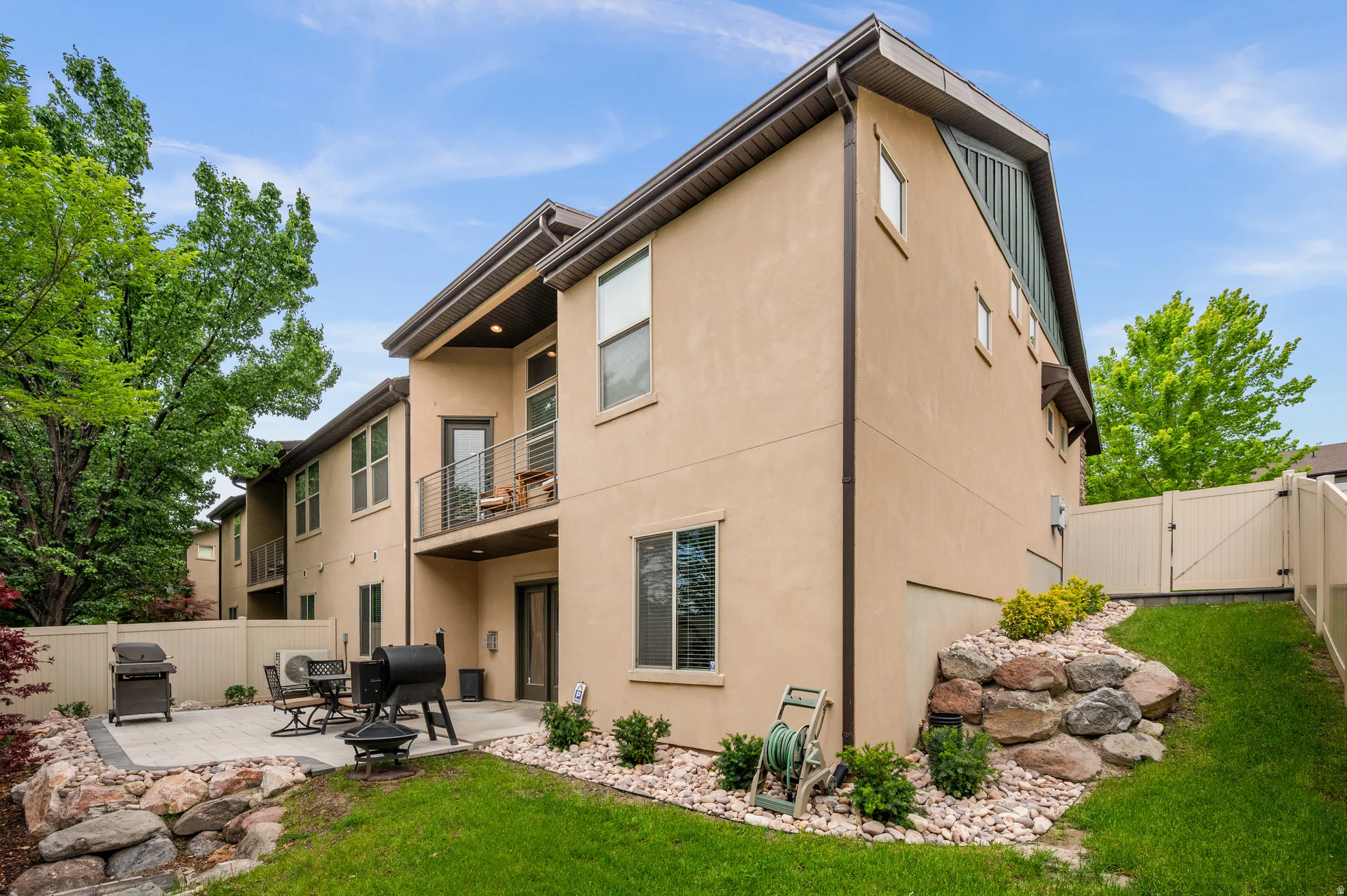 Exterior featuring stucco siding, multiple windows, and a second-story balcony with metal railings
