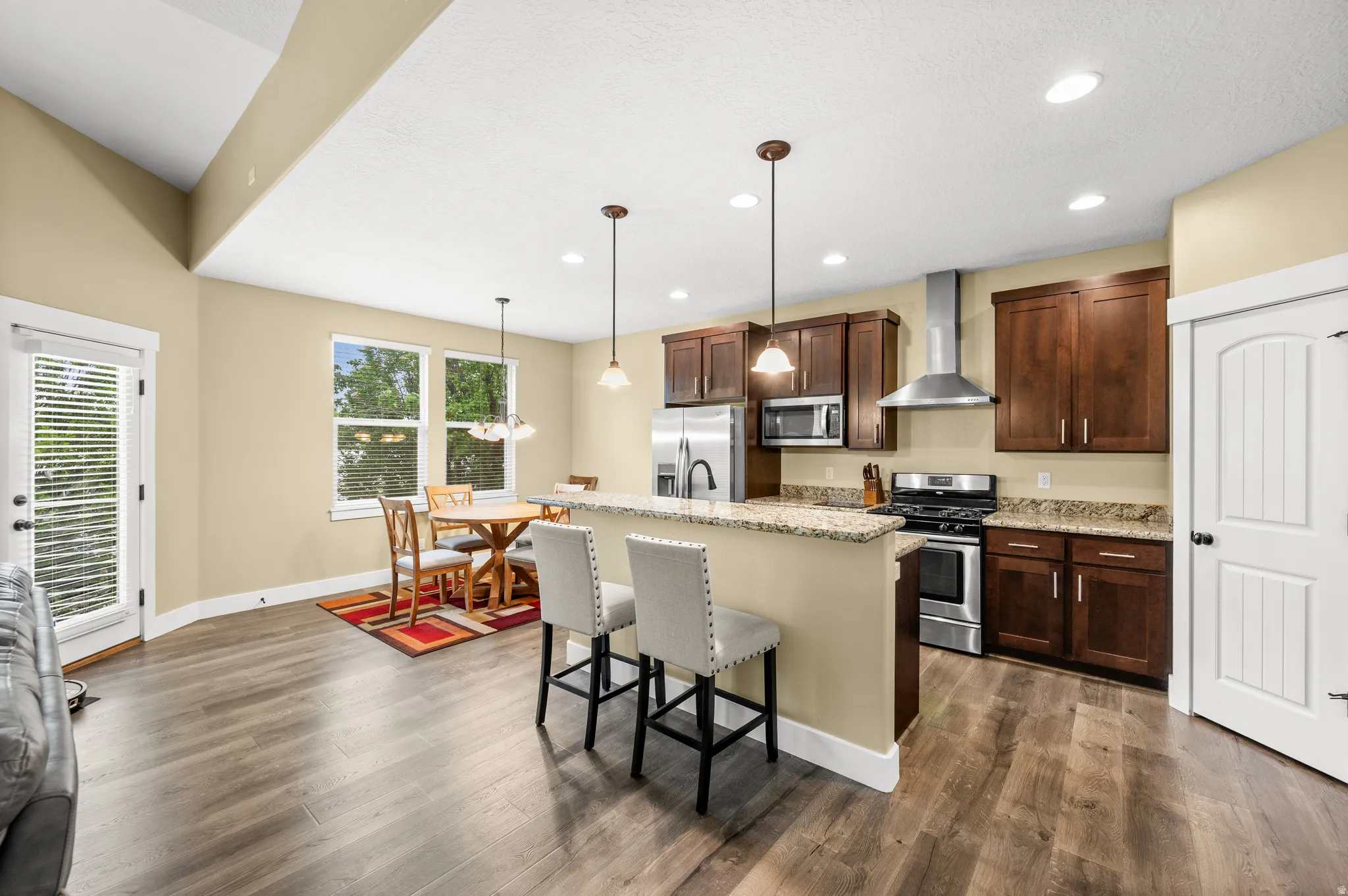 Kitchen featuring wood-finish flooring, granite countertops, and stainless steel appliances