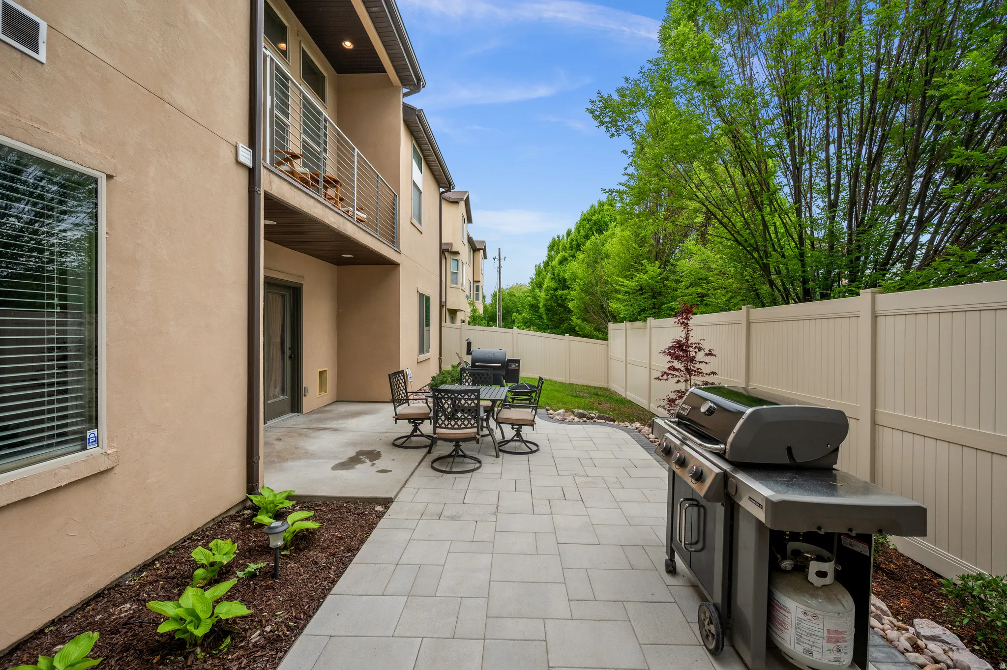Beautiful new paved patio area featuring light-toned pavers and a concrete section