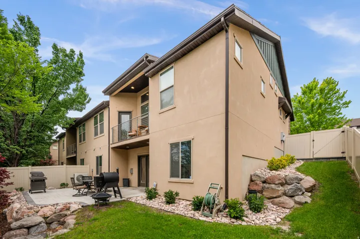 Exterior featuring stucco siding, multiple windows, and a second-story balcony with metal railings