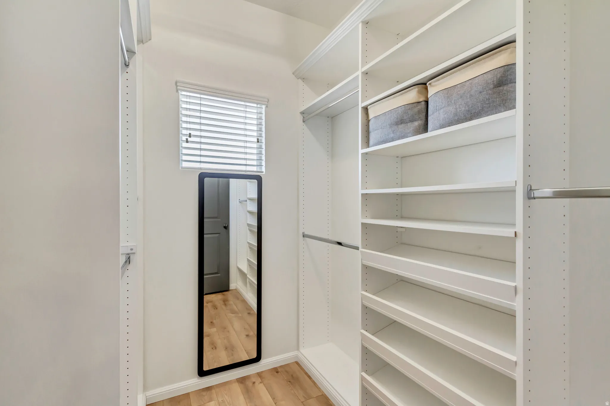 Custom closet system featuring white shelving and hanging rods