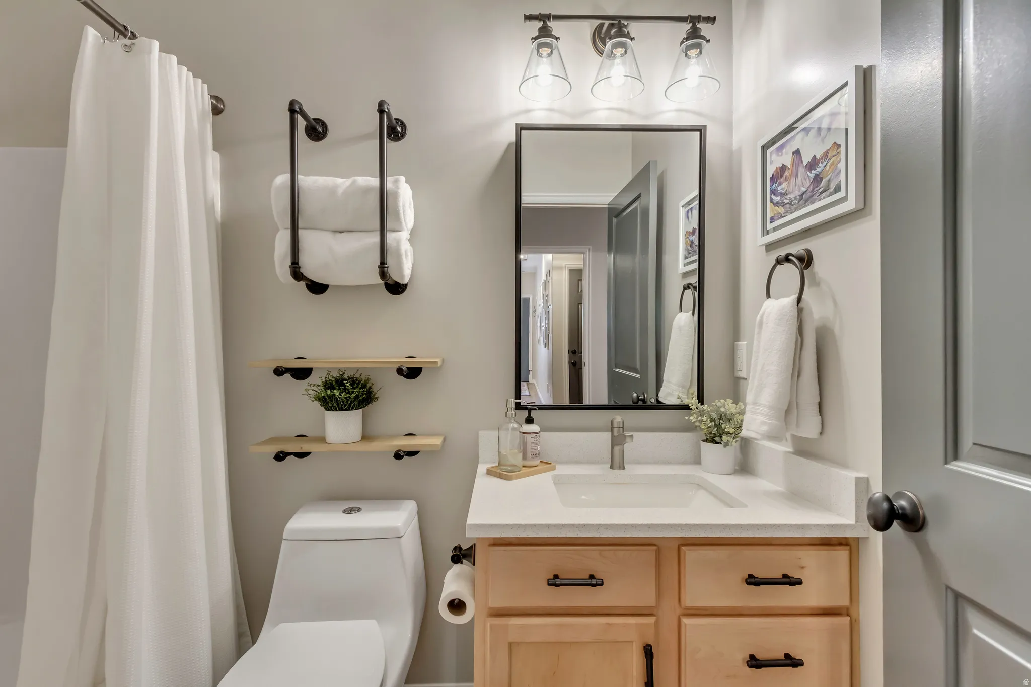 Bathroom adjacent to second primary bedroom featuring a light wood-finish vanity with dark hardware, a rectangular undermount sink, and a light-toned countertop