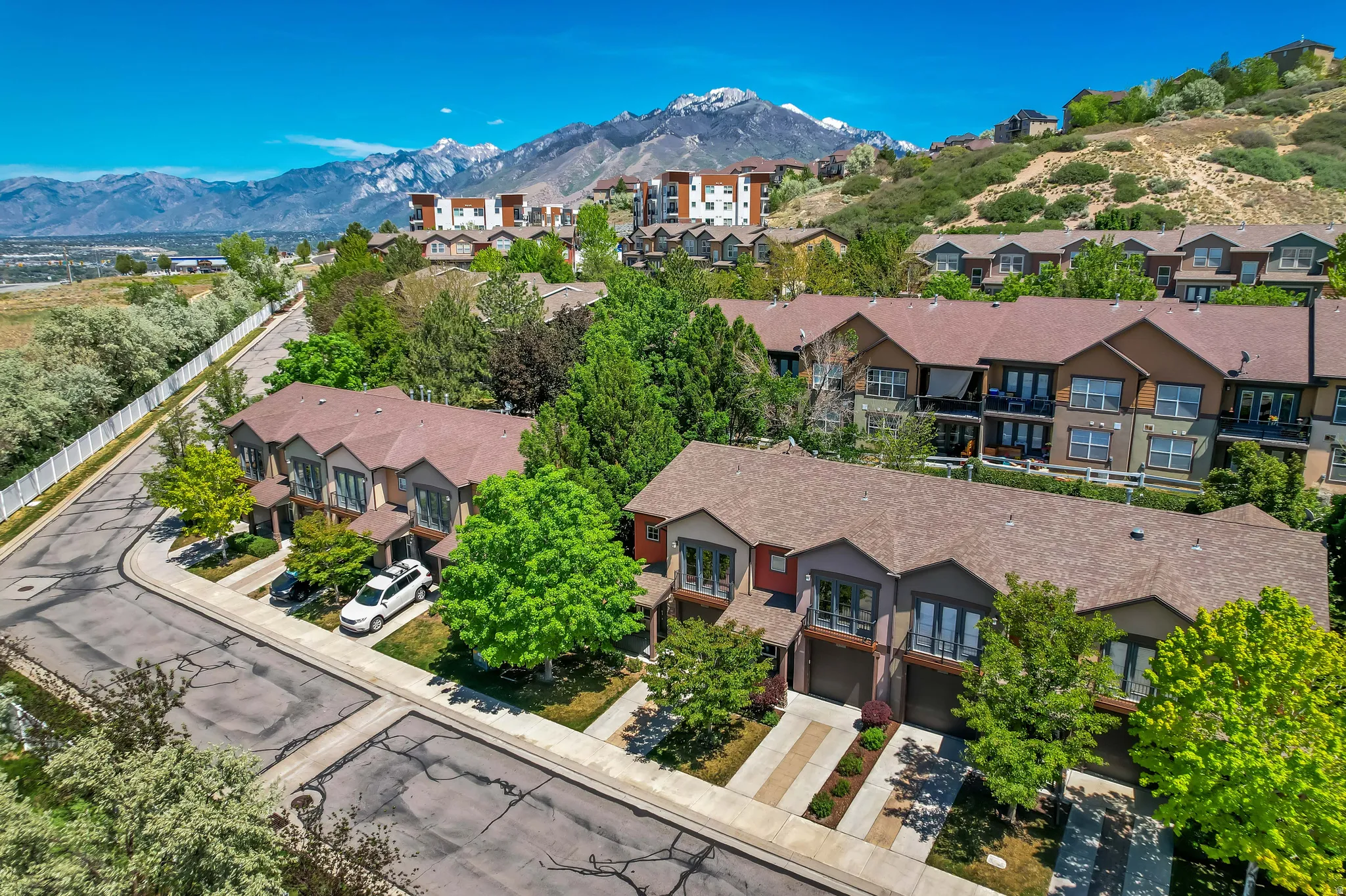 Contemporary townhome community with varied exterior finishes, attached garages, and individual patios