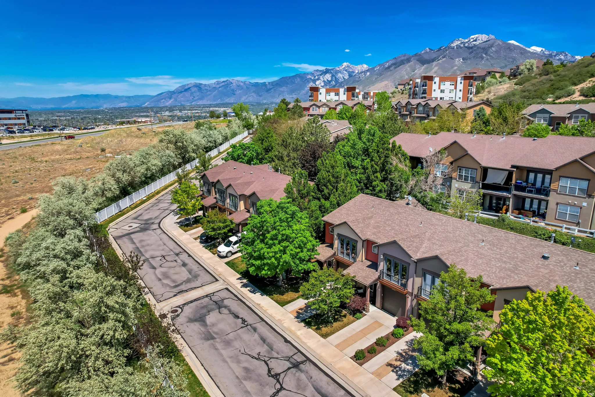 Community of townhomes situated on a sloping hillside with mature trees