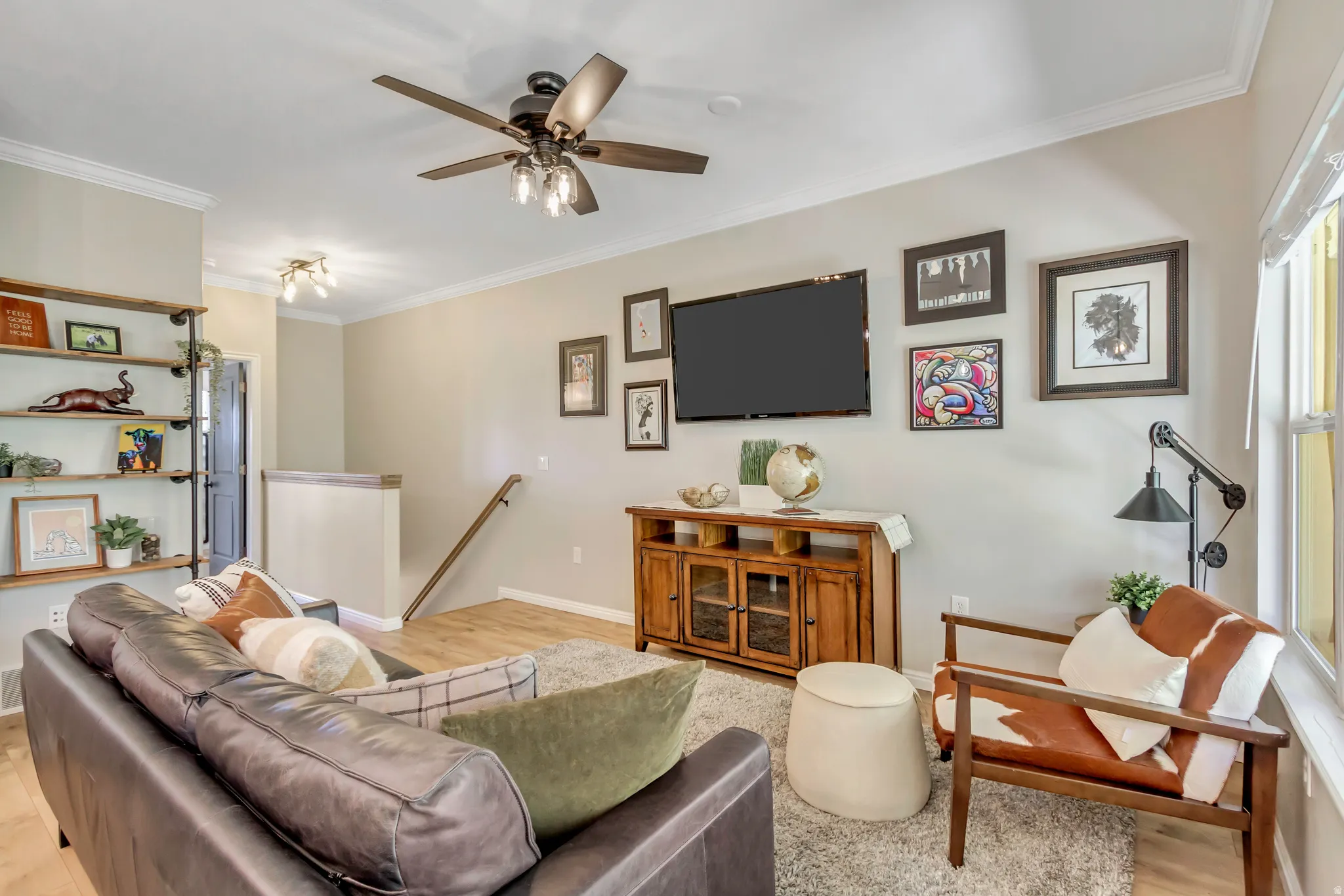Spacious living area featuring light-toned wall paint, bookshelves  and crown molding