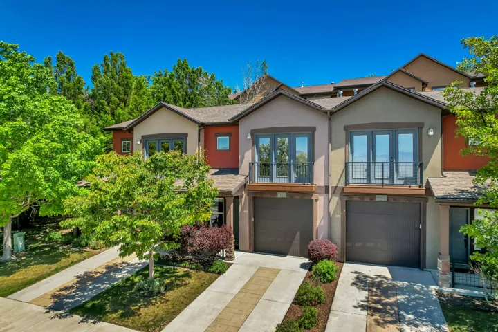 Multi-level townhome featuring a stucco exterior with varied earth-toned finishes