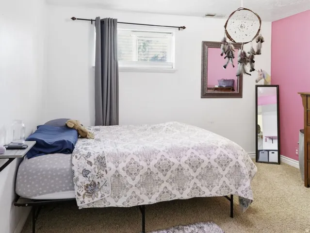 Bedroom featuring carpeting and a window with blinds