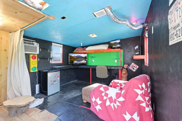 Compact interior space featuring black paneled walls and a blue ceiling