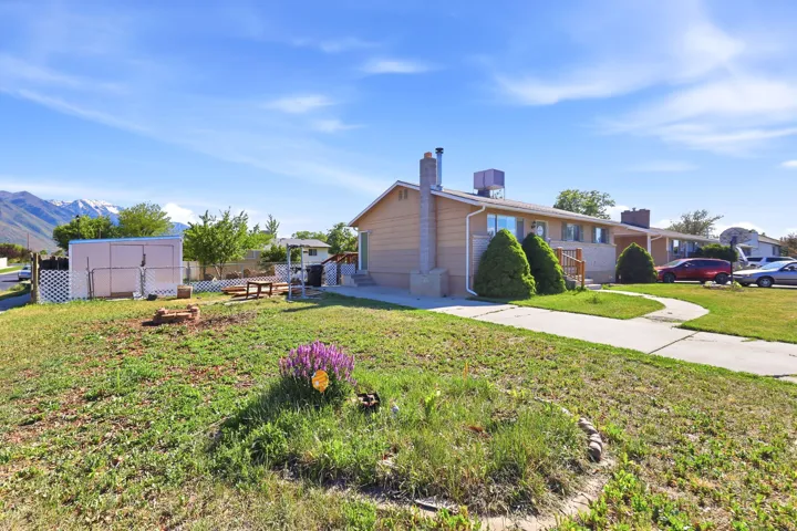 Ranch-style exterior with a stucco finish, a concrete walkway, and a spacious front lawn