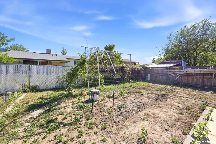 Expansive backyard space featuring an established garden area and mature perimeter landscaping