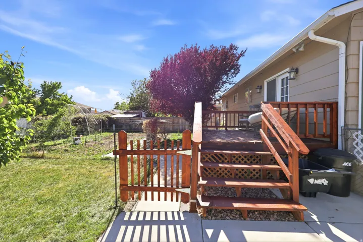 Expansive backyard featuring a multi-level wood deck, wood lattice under-deck skirting, a wood fence, and a gate