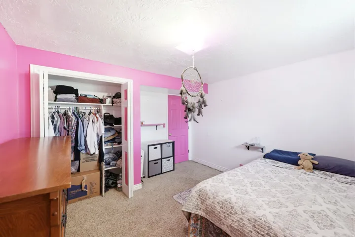 Room featuring a built-in closet with shelving and hanging rods
