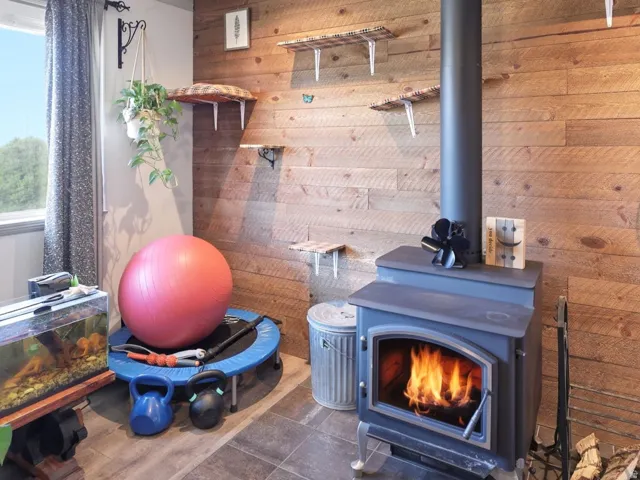 Wood-burning stove with a tile floor hearth, set against a paneled wood-finish accent wall